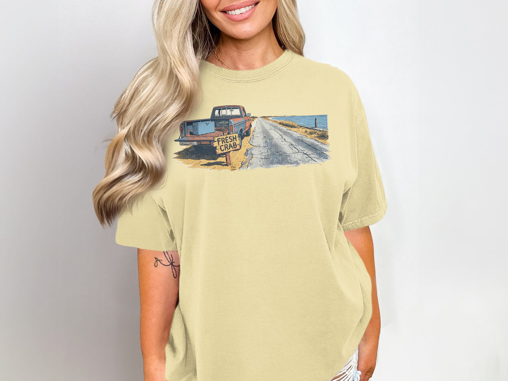 Yellow t-shirt with a graphic of a truck and "Fresh Crab" sign.