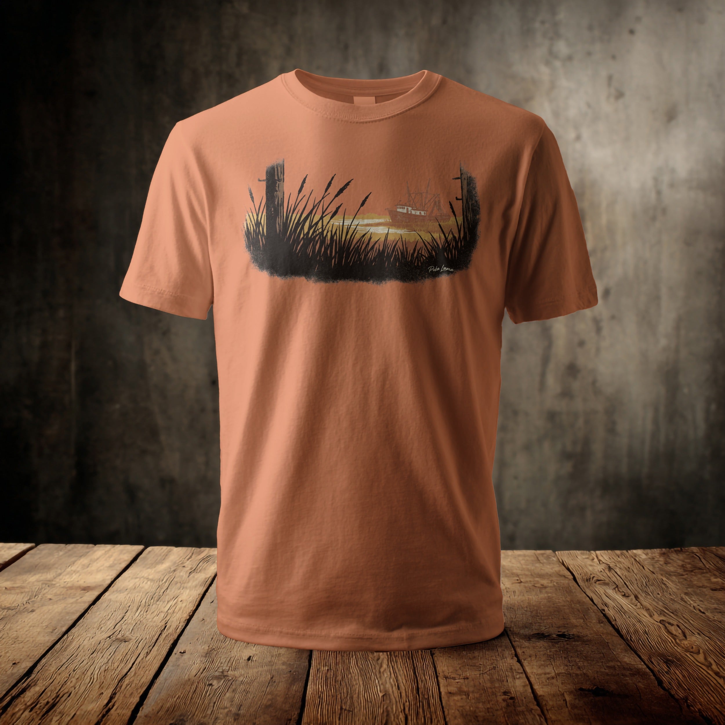 Orange t-shirt with a marsh scene and sailboat design.