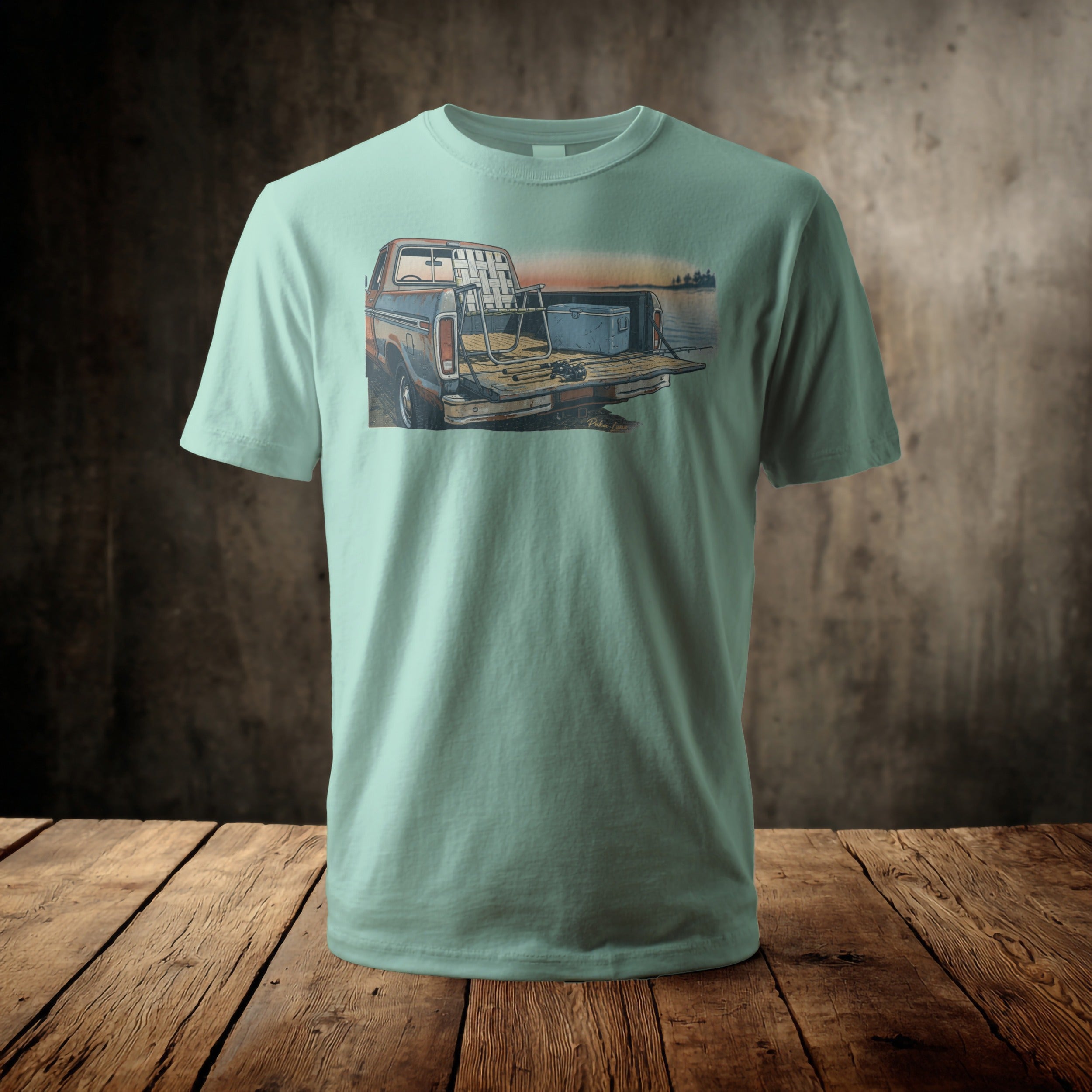 Mint green t-shirt with a graphic of a pickup truck bed filled with fishing gear.
