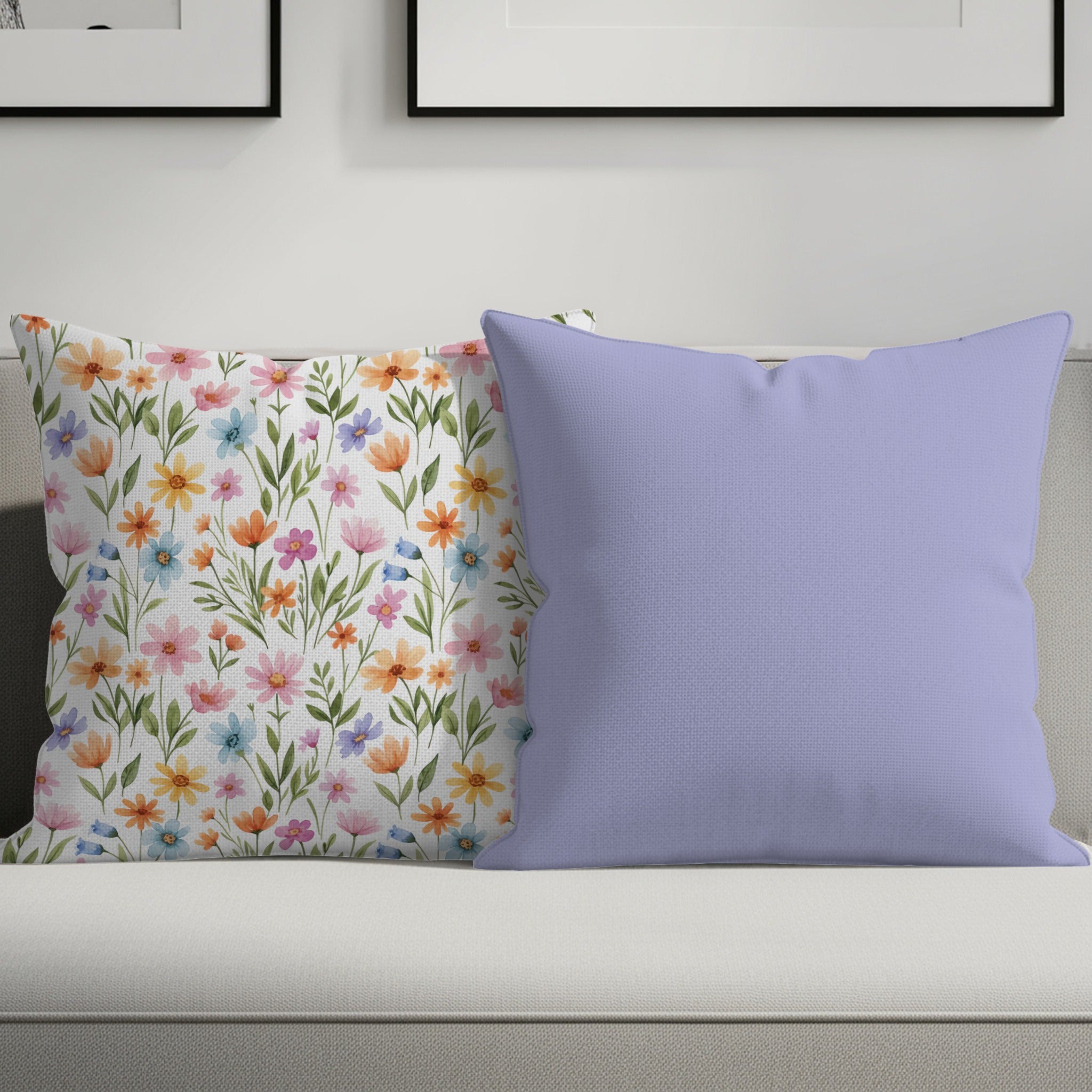 Two throw pillows on a couch, one floral, one solid lavender.