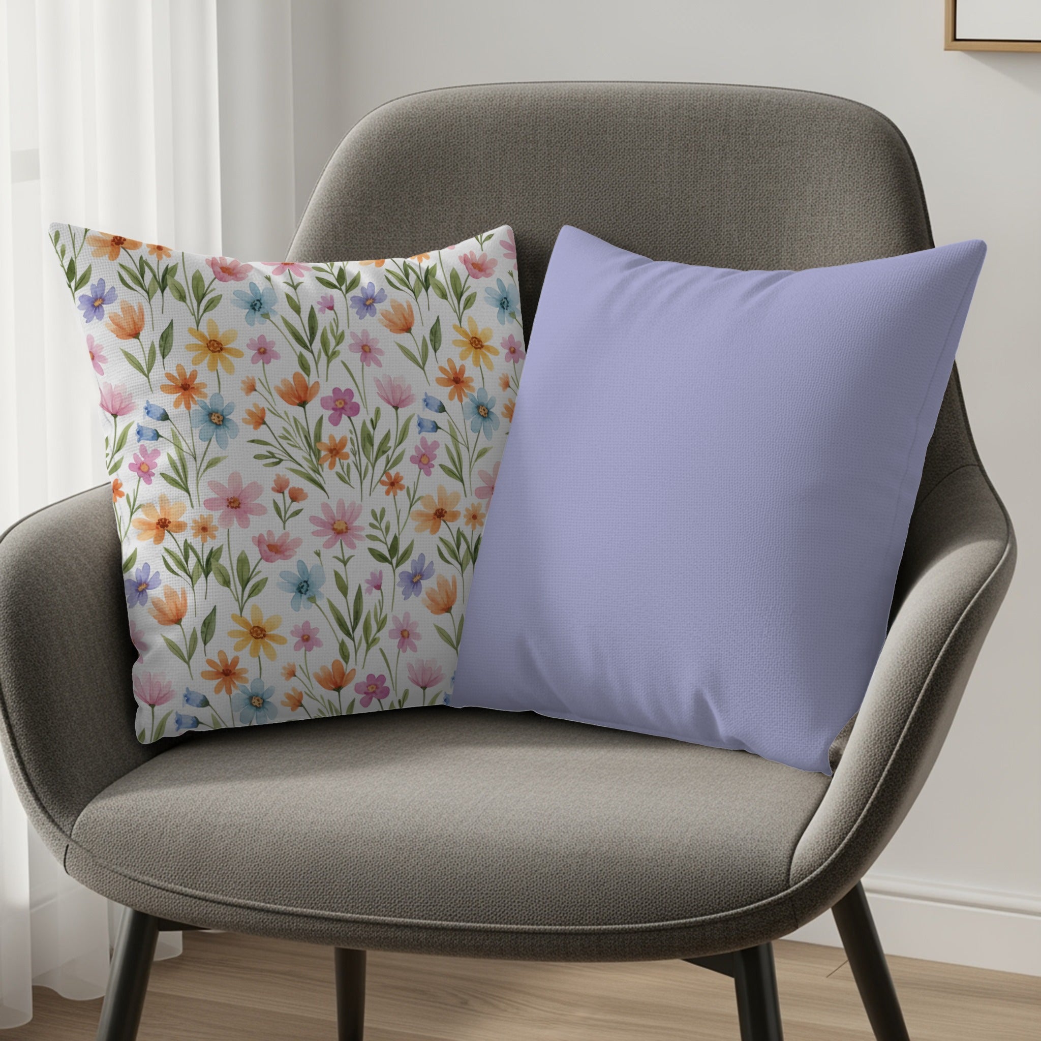 Two throw pillows on a gray chair, one floral, one solid purple.