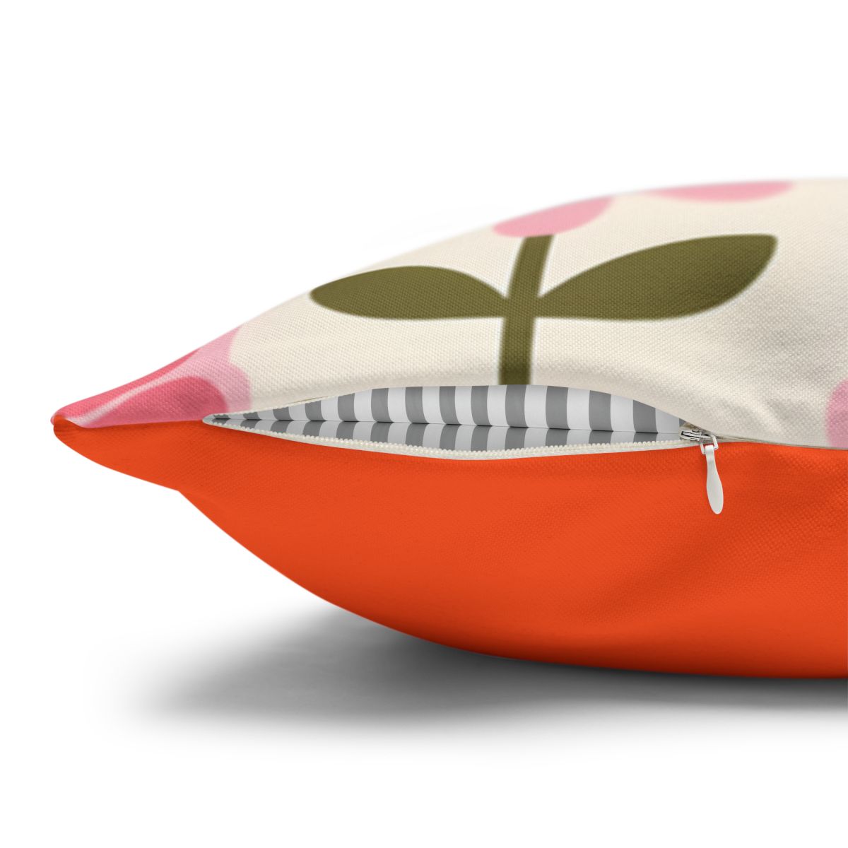 Orange pillow with a pink floral design and gray stripe detail.