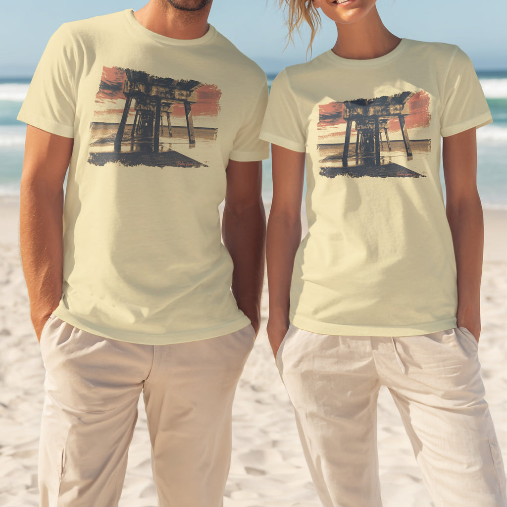 Light yellow t-shirts with sunset pier graphic on a beach.