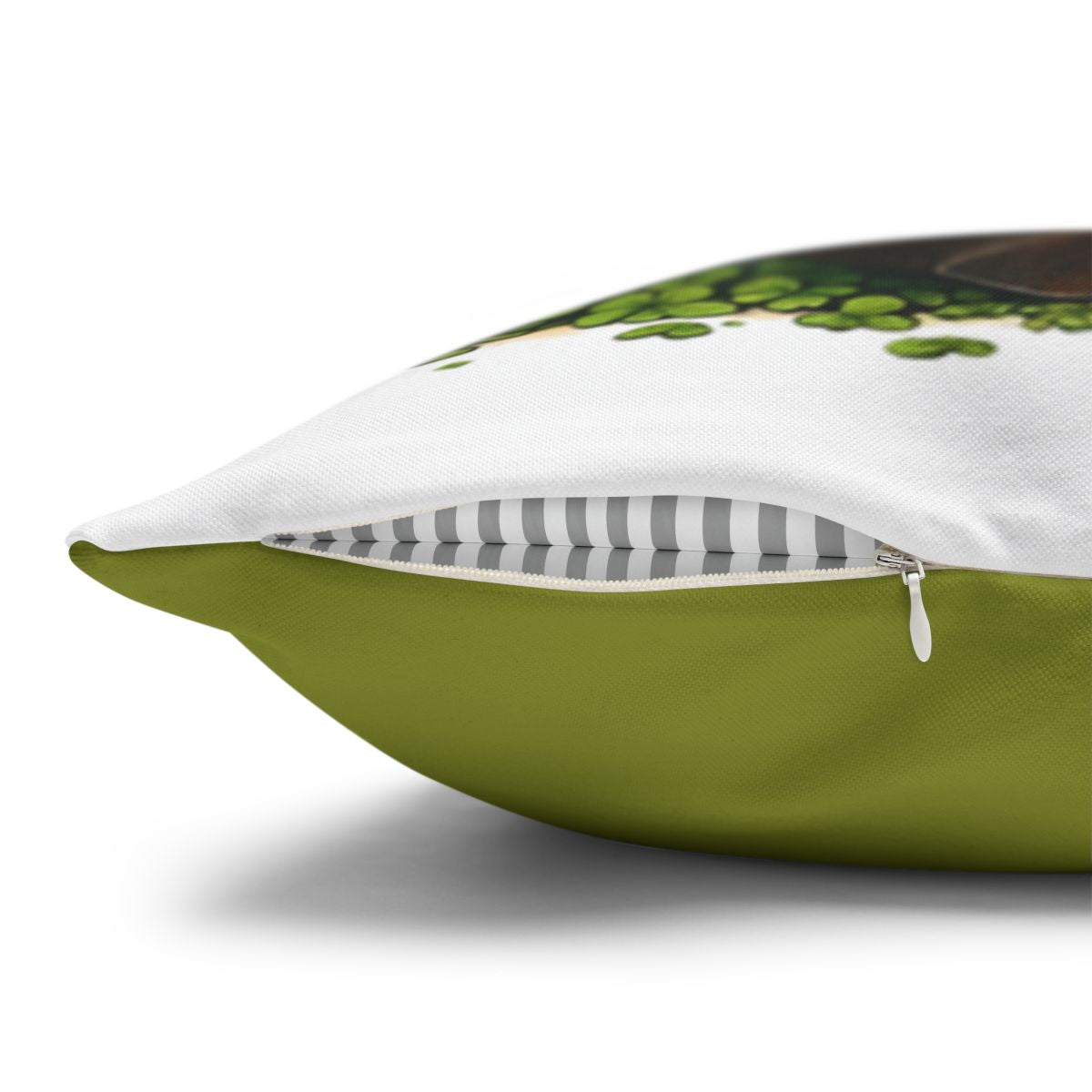 Green pillow with a partial view of a brown object and green leaves.