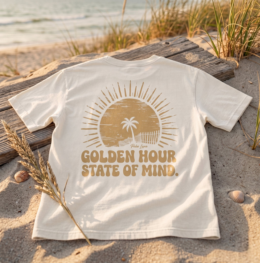 Cream t-shirt with "Golden Hour State of Mind" text and a sun with palm tree graphic.