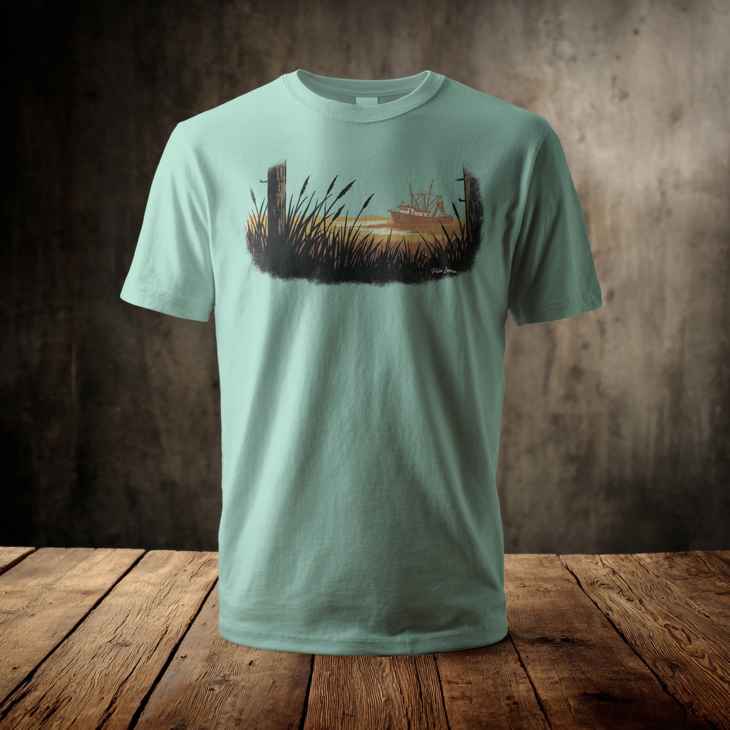 Light blue t-shirt with a watercolor-style graphic of a boat and reeds.