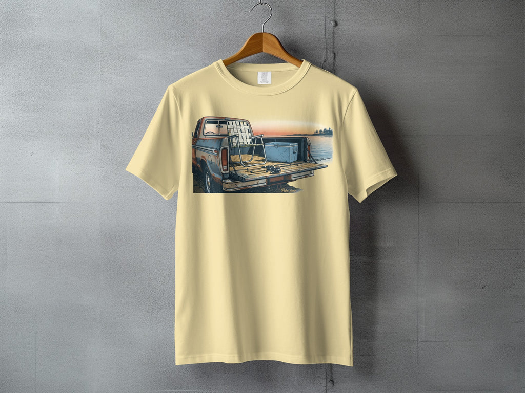 T-shirt with graphic of truck bed with cooler, chairs, and fishing rods.