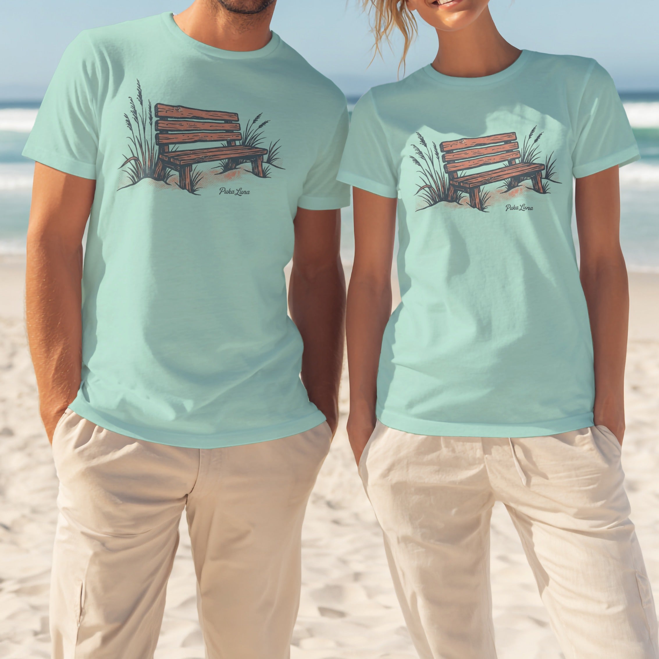 Two people in light blue t-shirts with a wooden bench and grass design.