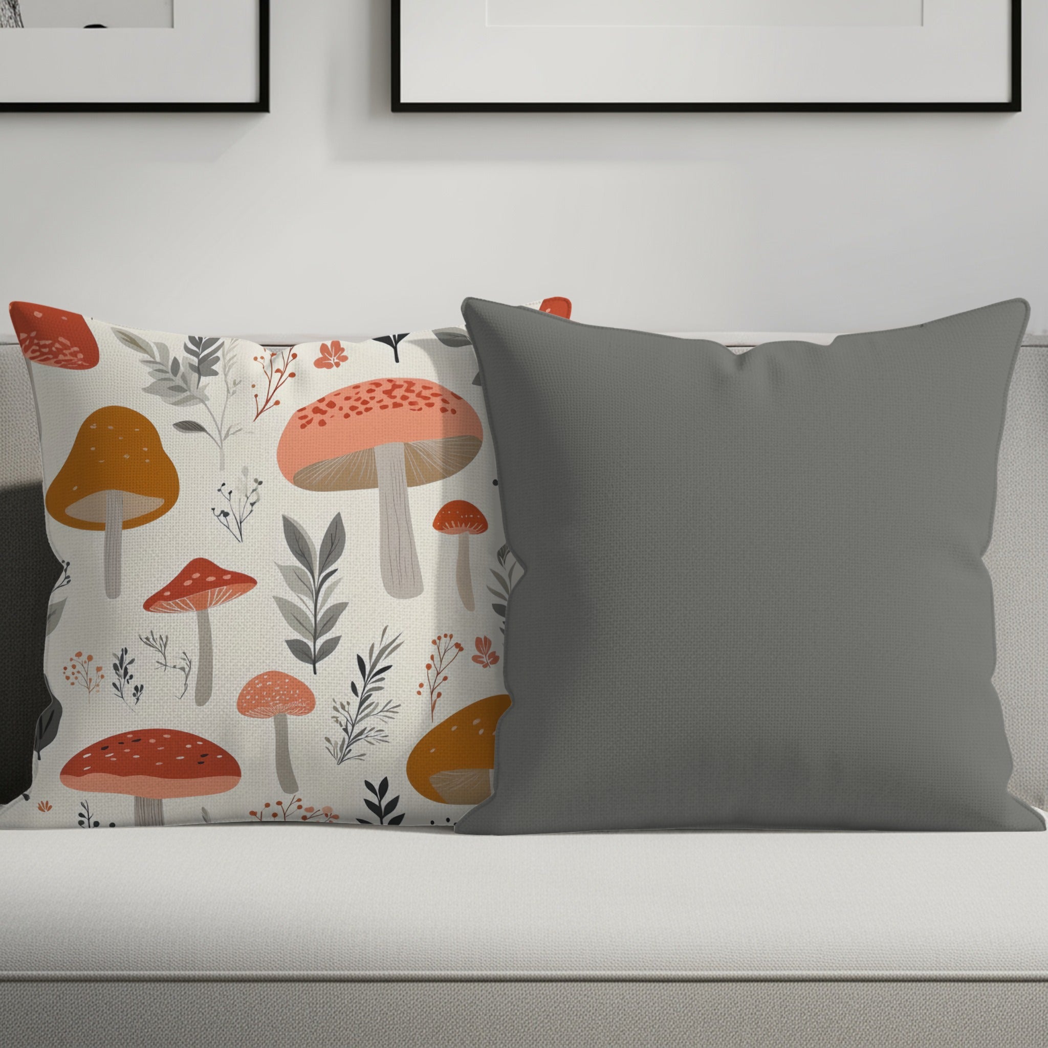 Two decorative pillows on a sofa: one with a mushroom print, one plain gray.