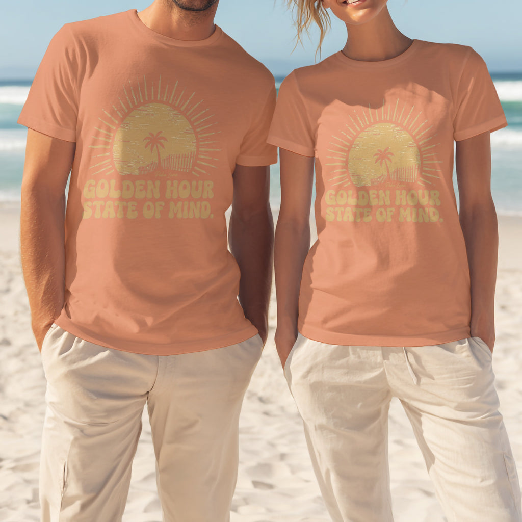 Two people wear peach t-shirts with "Golden Hour State of Mind" text and sun graphic.