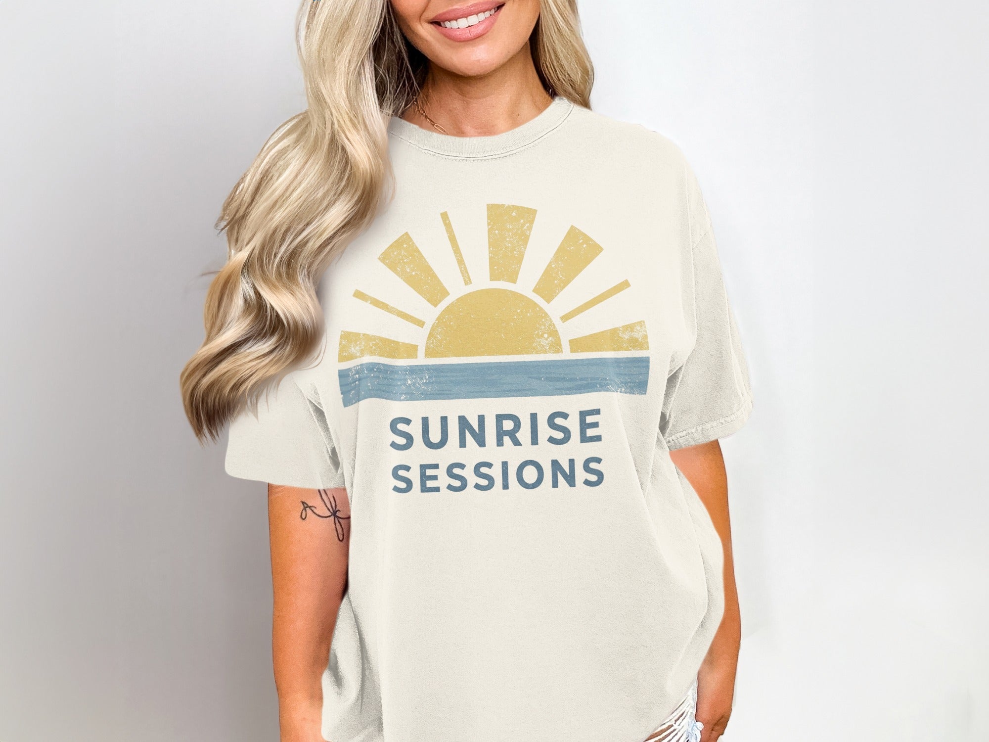 Cream t-shirt with "SUNRISE SESSIONS" text and a stylized sun graphic.