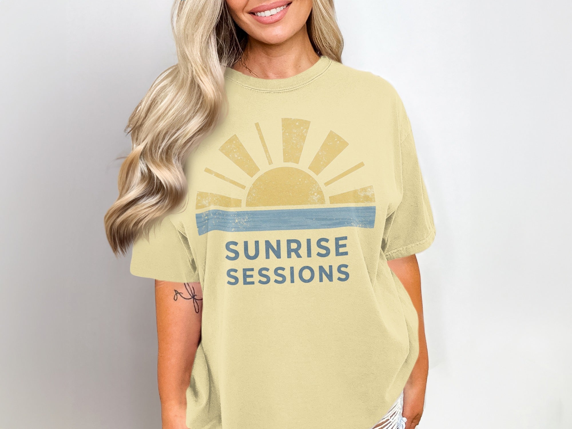 Yellow t-shirt with a sunrise graphic and "Sunrise Sessions" text.
