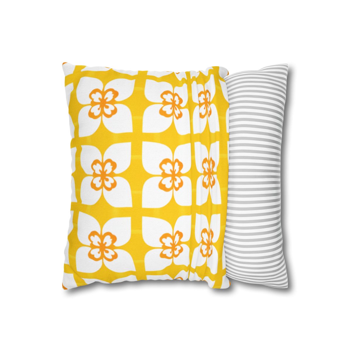 Yellow pillow with white and orange floral pattern next to a striped pillow.