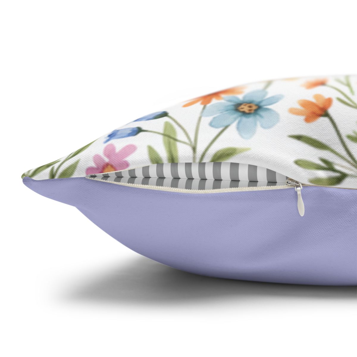Lavender pillow with a white floral pattern and gray striped accent.
