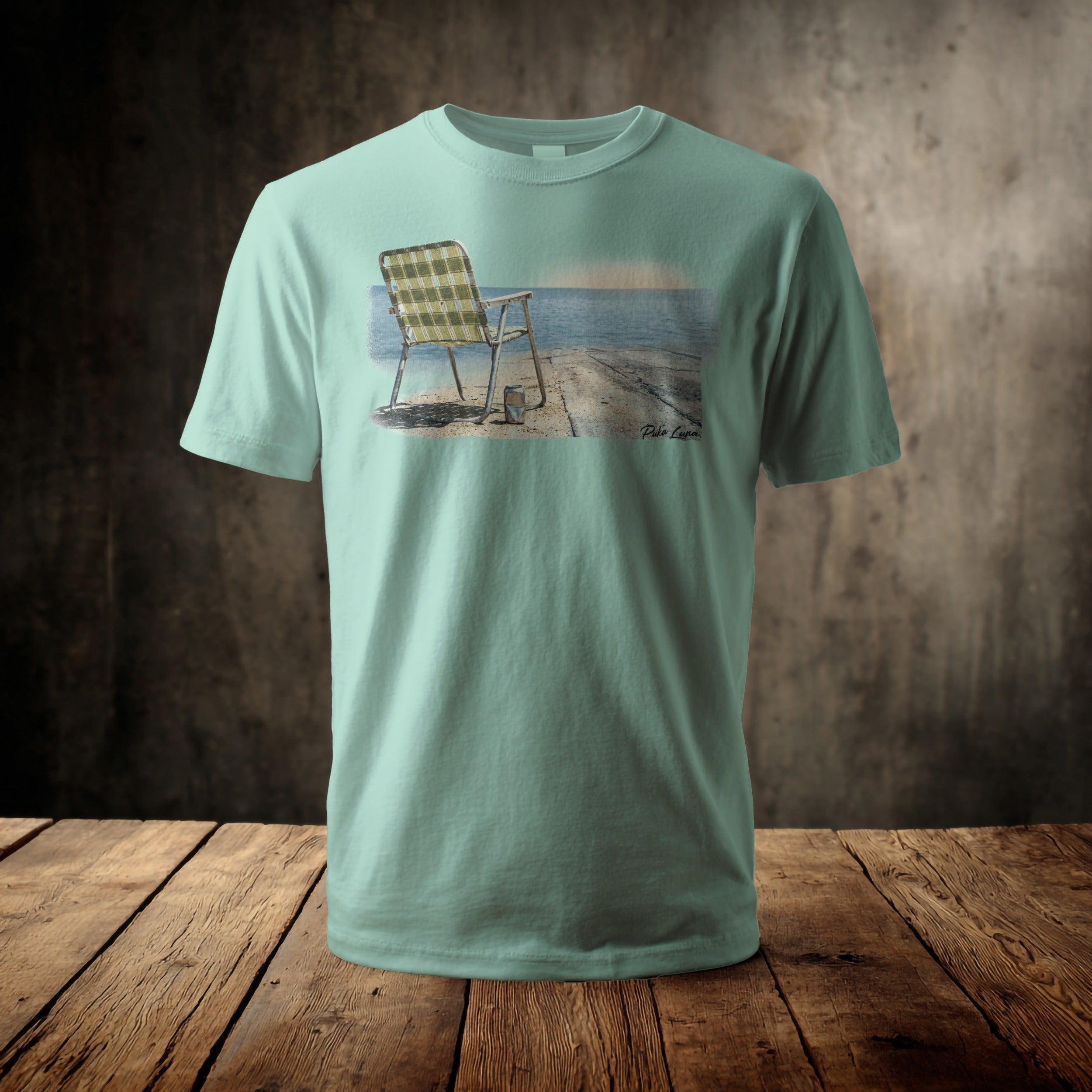 Pale green t-shirt with a printed image of a weathered chair on a pier.