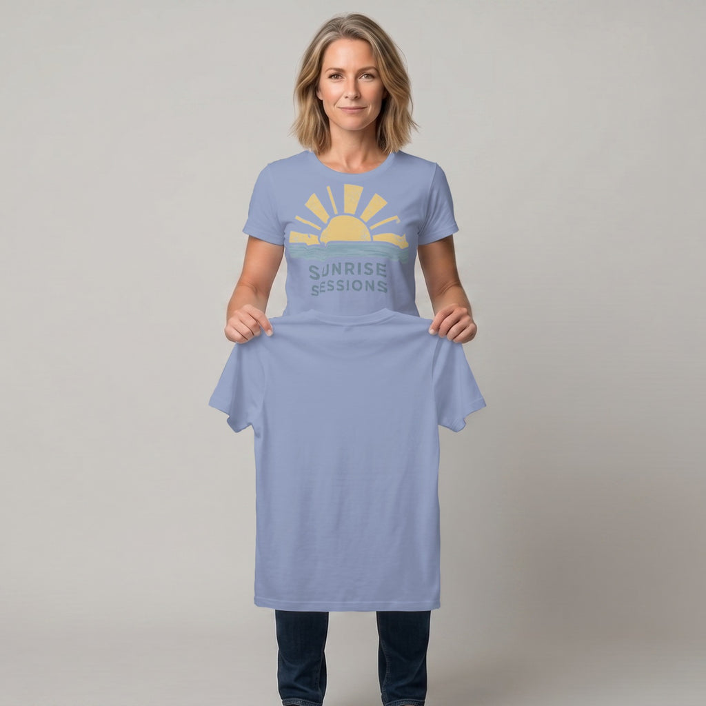Woman holding up a light blue t-shirt with a sunrise graphic and "SUNRISE SESSIONS" text.