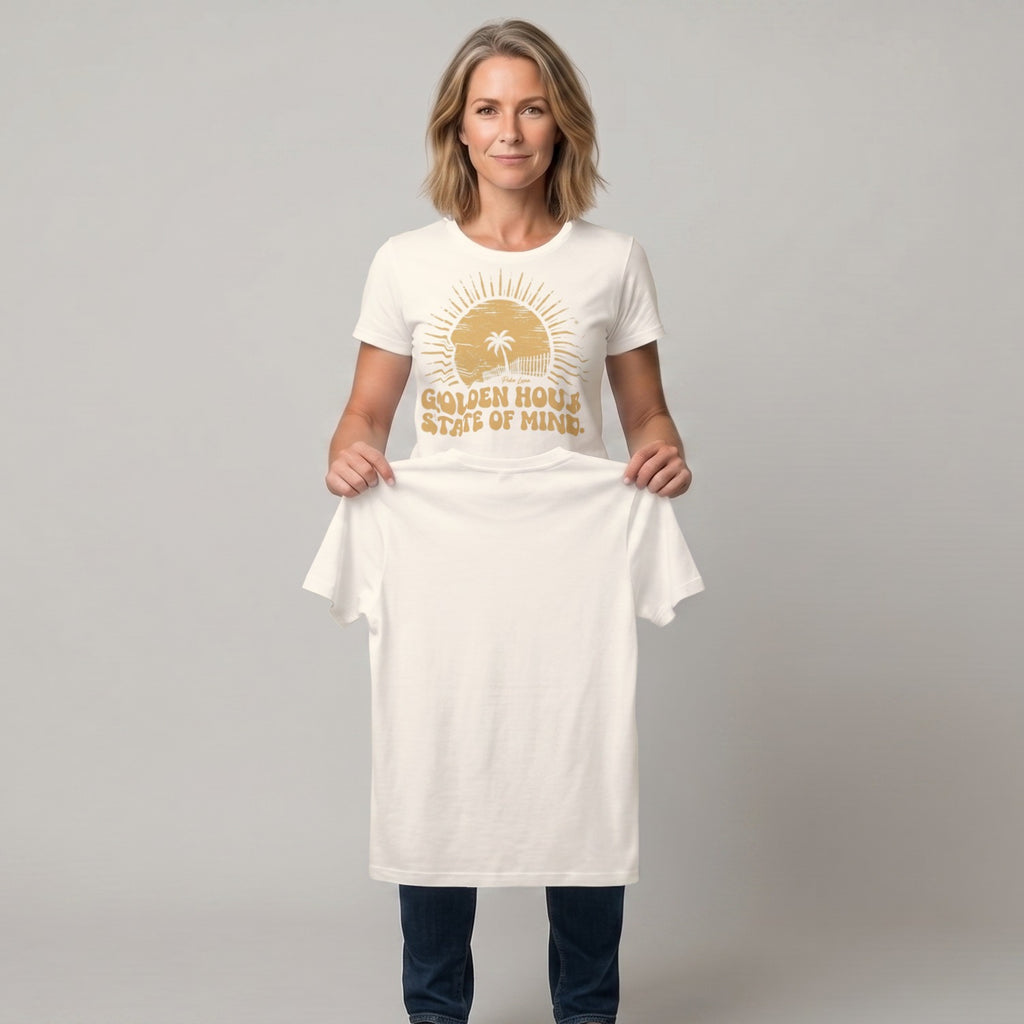Woman holding up a plain white t-shirt with sun graphic and text.