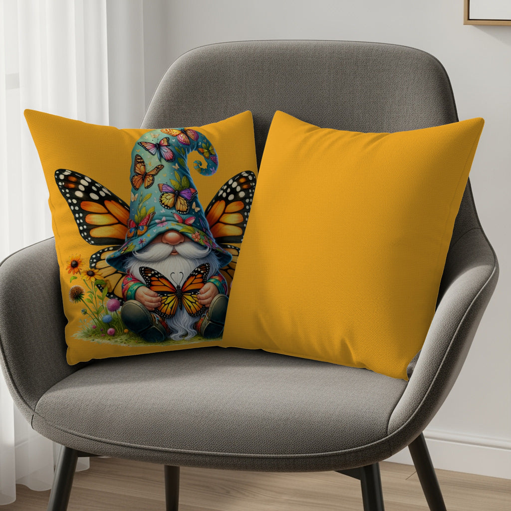 Gnome with butterfly wings and hat, holding a butterfly, sits with two yellow pillows.
